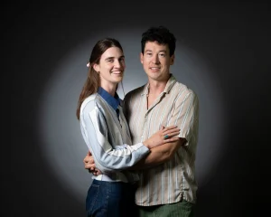 Couple embracing in front of a grey studio backdrop
