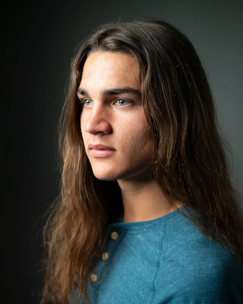 Young man with long hair in profile