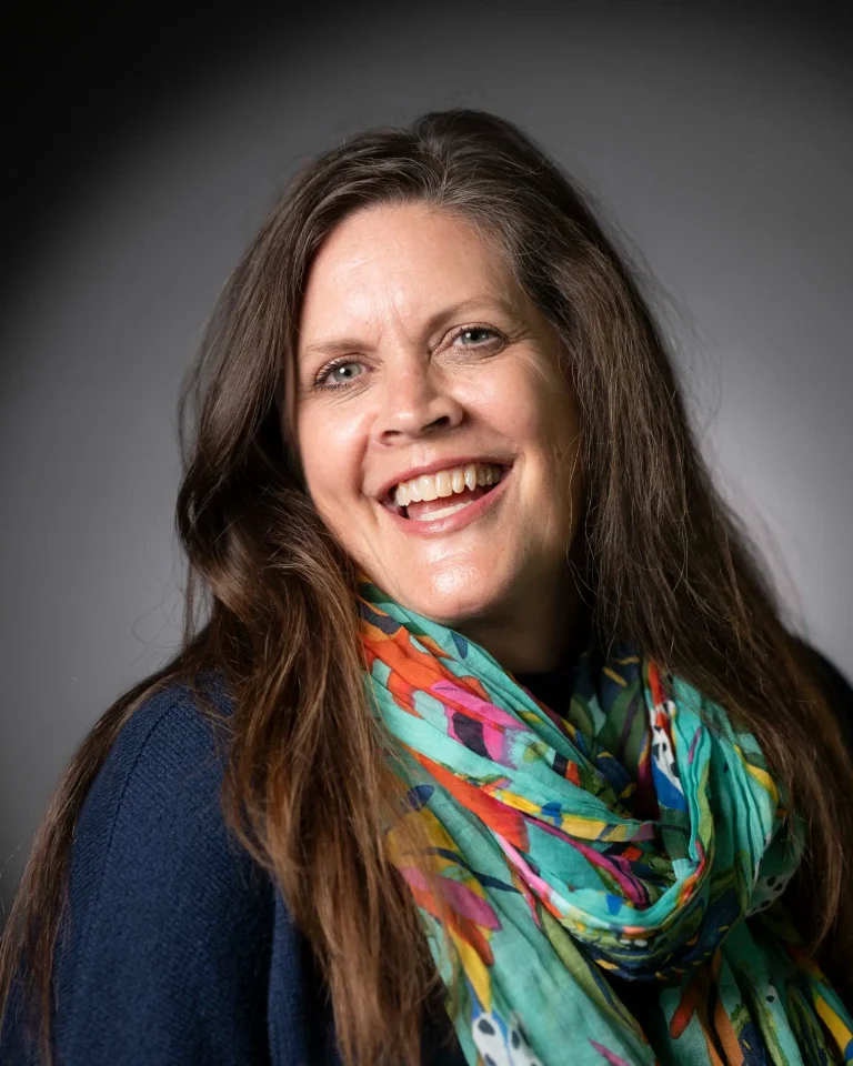 Smiling woman with a colourful scarf, studio light