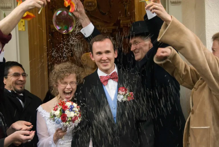 Laughing newlyweds showered with rice outside the church